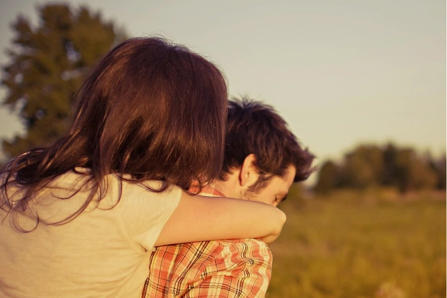 Jovem casal abraçados num espaço verde