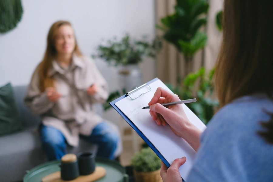 Terapeuta em sessão de psicologia clínica com uma mãe